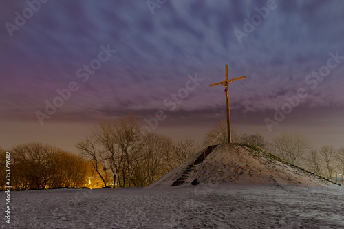 Krzyż Chrześcijański nocą na ośnieżonej górce.