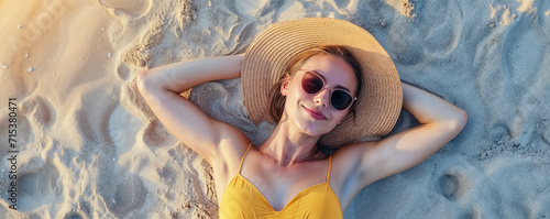 une femme allongée sur le dos, les bras derrière la tête, sur une plage de sable