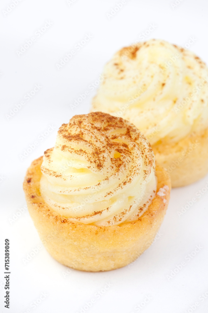 Mini South African milk tart cups isolated on white with copy space and selective focus Mini South African milk tart cups isolated on white with copy space and selective focus