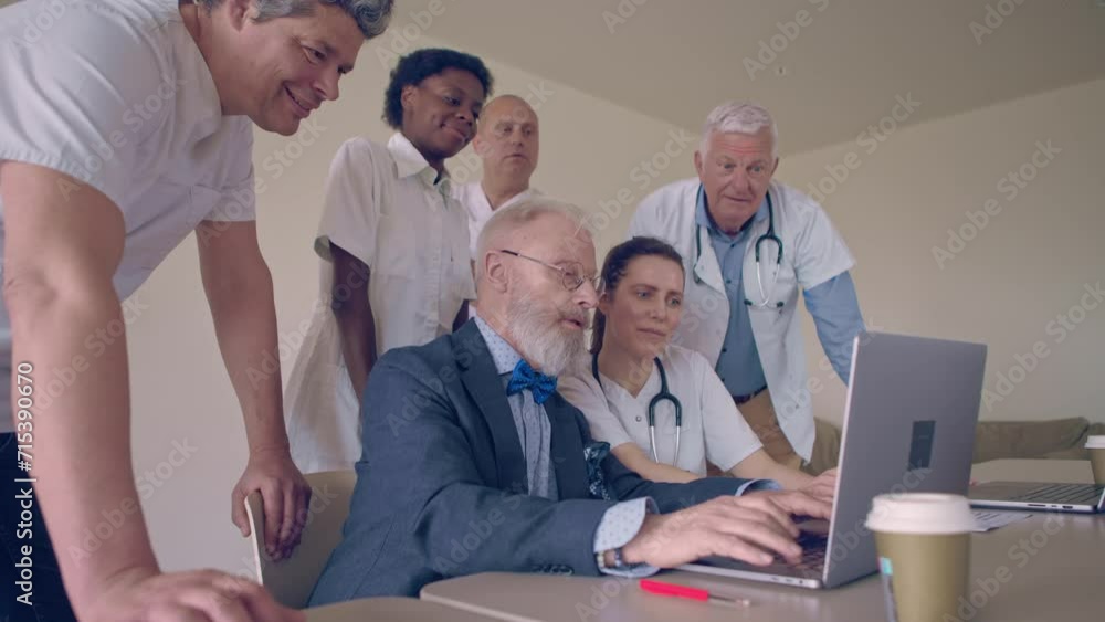 group of medical researchers in a meeting room, gathered around a laptop to discuss their project group of medical researchers in a meeting room, gathered around a laptop to discuss their project