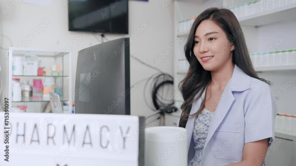 Young Asian pharmacist woman working on computer at drug store. Cheerful Asia apothecary female typing lists of medicine in computer smiling at pharmacy shop. Young Asian pharmacist woman working on computer at drug store. Cheerful Asia apothecary female typing lists of medicine in computer smiling at pharmacy shop.