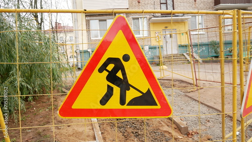 Road works signs on a fence, construction and building industry.