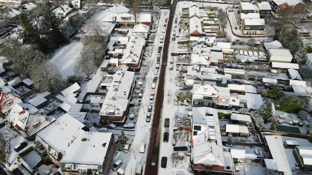 Aerial of car driving over a clean road in a beautiful snow covered town Aerial of car driving over a clean road in a beautiful snow covered town