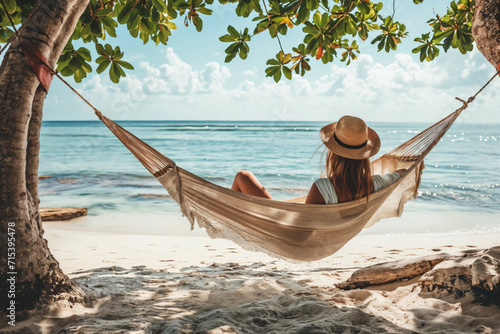 A woman in a sun hat enjoys a peaceful moment in a hammock, swaying gently by the seaside, with lush green foliage framing the tranquil ocean view