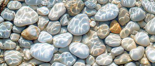 Creative wallpaper abstract image of white rounded smooth pebble stone under transparent water with waves. Backdrop sea bottom pattern surface. Top view 