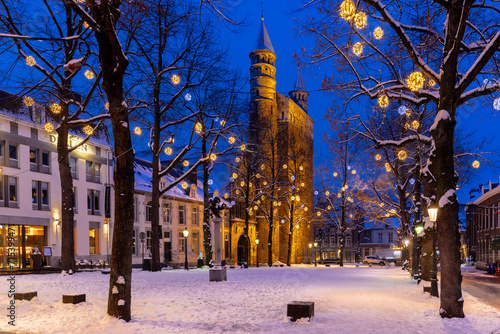 Maastricht, Netherlands 01-19-2024 Basilica of Our Lady and the square during twilight, covered with fresh snow during winter time and illuminated with Christmas decoration, creating a magical scene 