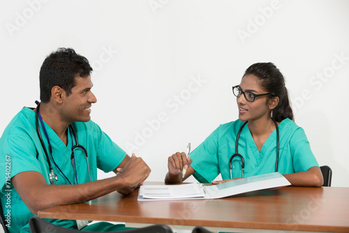 Two Indian doctors sitting working at a desk together photo