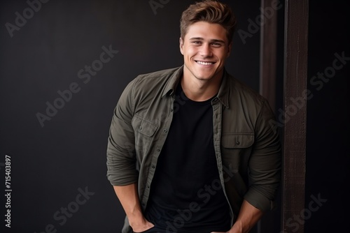 Portrait of a handsome young man smiling at the camera. Studio shot.