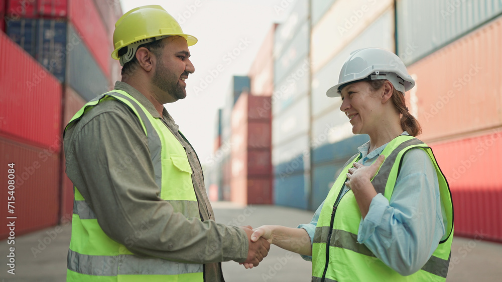 Two industrial engineers man and woman shake hands to celebrate success work together at cargo container yard. Logistic shipping yard business. Teamwork concept Two industrial engineers man and woman shake hands to celebrate success work together at cargo container yard. Logistic shipping yard business. Teamwork concept