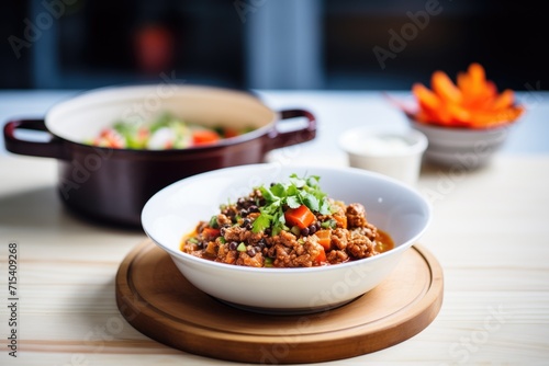 ladling chili con carne from pot to bowl