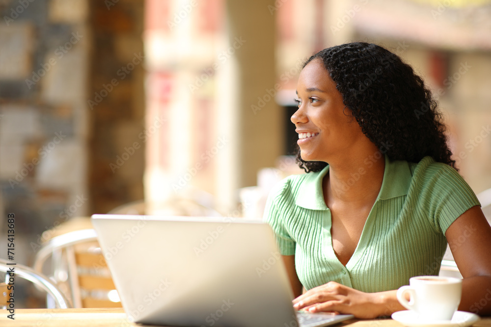Happy black woman with laptop dreaming Happy black woman with laptop dreaming