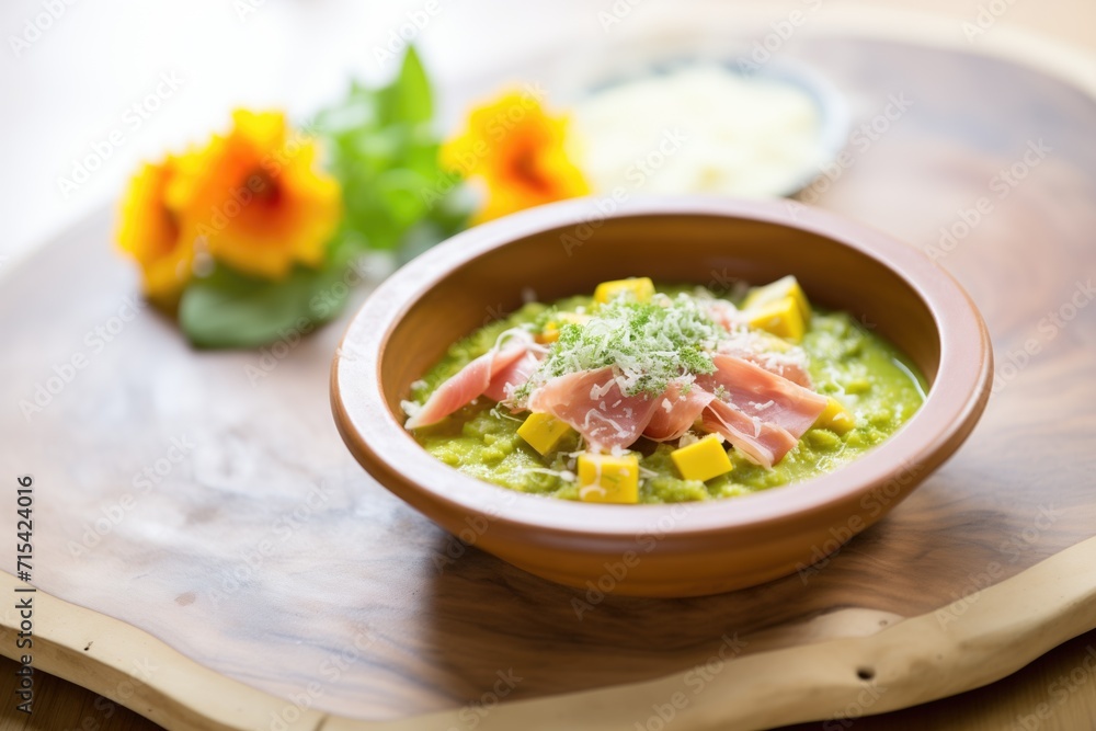 split pea soup with ham chunks in a deep dish, mint leaf garnish split pea soup with ham chunks in a deep dish, mint leaf garnish