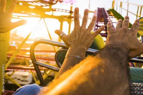 Tablou pe pânză Pov of Couple on a roller coaster with arms in the air amused and excited waiting for the steep descent