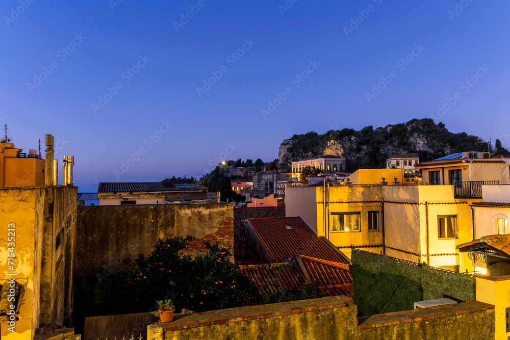 evening landscape of antique night european town with flashlights, buildings and mountains, Italian mediterranean city view