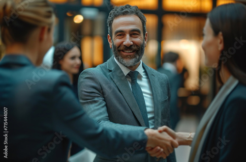 businessman shaking hands at an office with people around. © olegganko