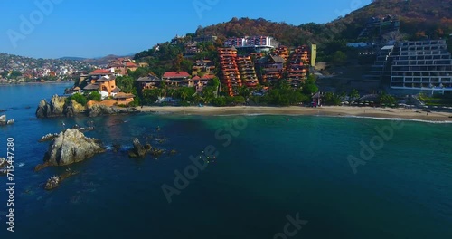 A beautiful home sits on a rocky point in a picture-perfect Mexican town along the coast of the calm water bay in Zihuatanejo photo