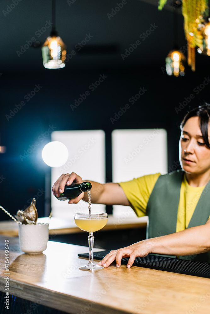 Bartender pouring drink in cocktail glass on bar counter Bartender pouring drink in cocktail glass on bar counter