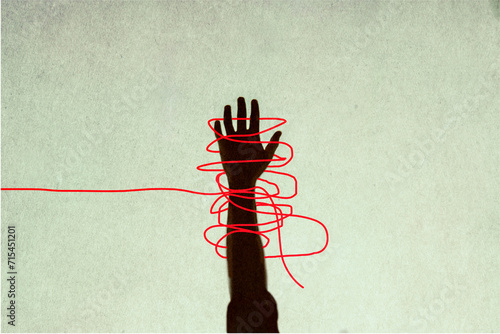 Human hand trapped in red tangled strings photo