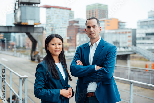 Businessman and businesswoman standing in front of buildings photo
