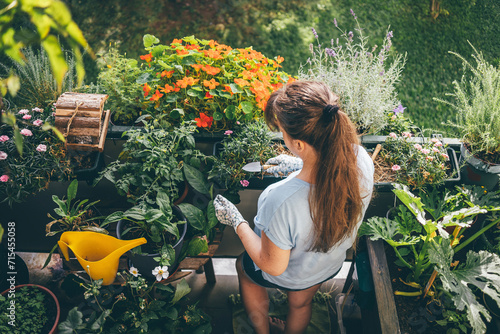 Woman holding trowel and doing gardening in balcony photo