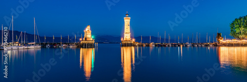 Germany, Bavaria, Lindau, Harbor of town on shore of lake Bodensee at night with lighthouse andBavarian Lion sculpture in background photo