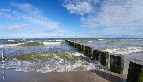 baltic sea blue sky wave sea and wooden waterbreak photo