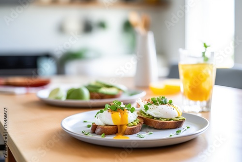 brightly lit scene of avocado toast with poached egg, orange juice