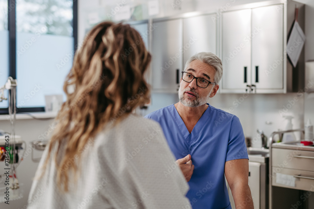 Doctor showing female patient MRI scan on tablet, discussing test result in emergency room. Doctor showing female patient MRI scan on tablet, discussing test result in emergency room.