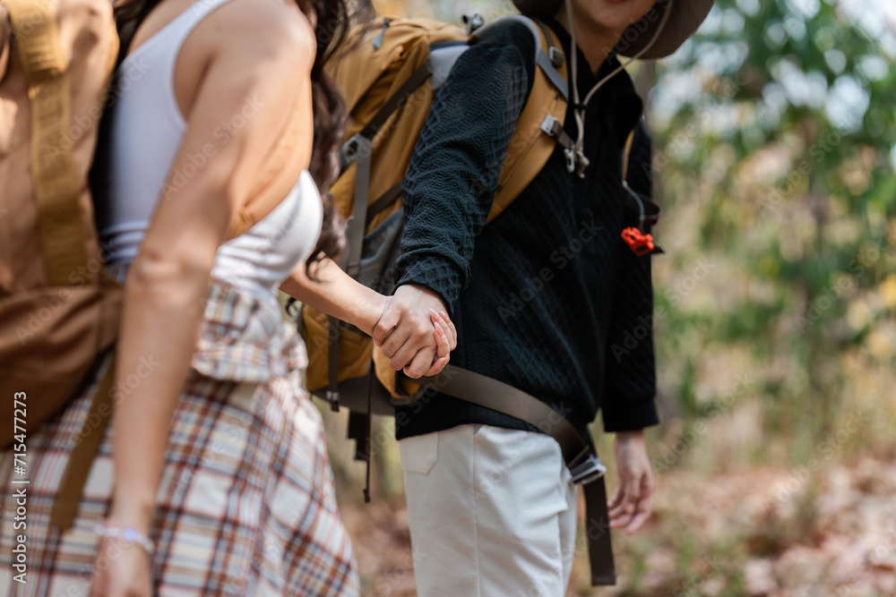 © itchaznong - Happy LGBT Lesbian couple Travelers Hiking with Backpacks in forest Trail. LGBT Lesbian Couple Hikers with backpacks walks in mountains in vacation