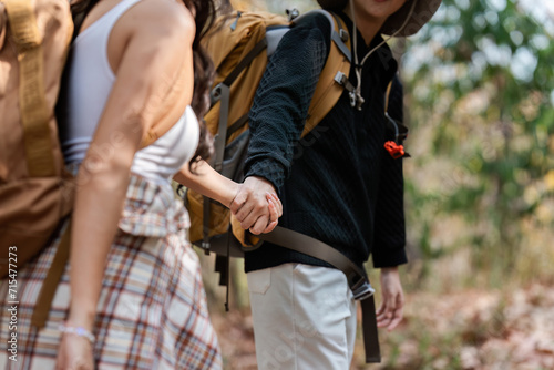 Happy LGBT Lesbian couple Travelers Hiking with Backpacks in forest Trail. LGBT Lesbian Couple Hikers with backpacks walks in mountains in vacation