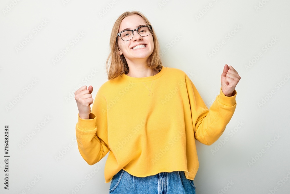Portrait of smiling face girl clenching fists and rejoicing, celebrating victory isolated on white studio background, advertising banner. Portrait of smiling face girl clenching fists and rejoicing, celebrating victory isolated on white studio background, advertising banner.