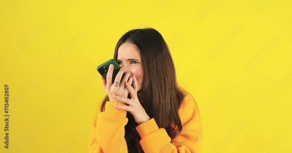 Angry woman talking on speaker phone or voice message or frustrated communication and crazy online chat on social media. Mobile, conversation, girl with stress story and audio note or call on yellow. Angry woman talking on speaker phone or voice message or frustrated communication and crazy online chat on social media. Mobile, conversation, girl with stress story and audio note or call on yellow.
