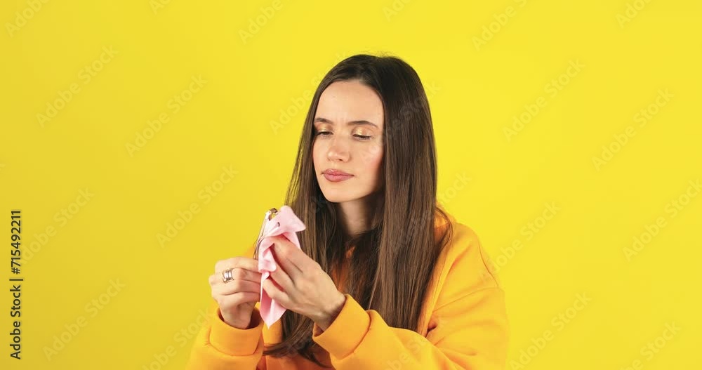 Caucasian woman cleaning glasses or lens with microfiber tissue isolated on yellow background. Healthcare, vision, optical care, lens hygiene, eyeglass longevity and medicine concept. Caucasian woman cleaning glasses or lens with microfiber tissue isolated on yellow background. Healthcare, vision, optical care, lens hygiene, eyeglass longevity and medicine concept.