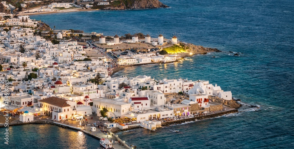 Aerial view of the old town of Mykonos island with Litte Venice district and the famous windmills during dusk, Cyclades, Greece