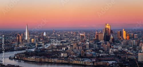Wide panoramic view of the London skyline during dawn with pink colors and soft sunlight reflecting from the City skyscrapers  England