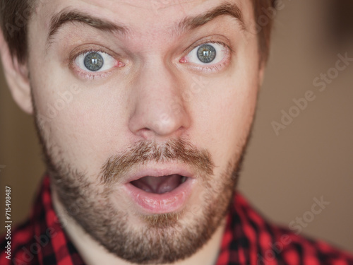 Man with surprised face. Portrait on the beige background.