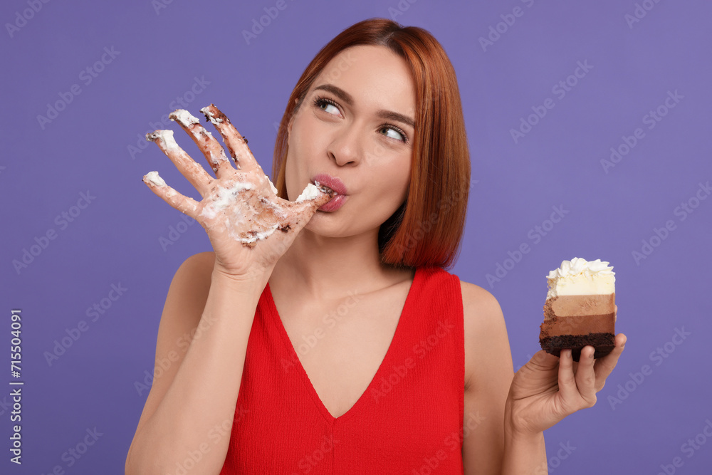 Young woman eating piece of tasty cake on purple background Young woman eating piece of tasty cake on purple background