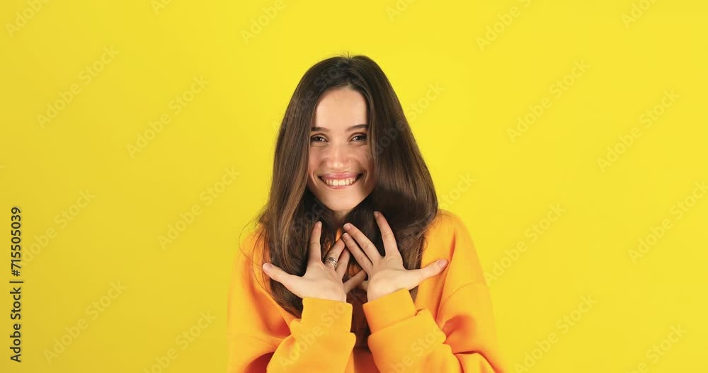 Brunette woman put folded palms on heart. Sign and symbol of love, sincere grateful kind person express candid feelings. Benevolence and charity concept isolated on yellow background. Brunette woman put folded palms on heart. Sign and symbol of love, sincere grateful kind person express candid feelings. Benevolence and charity concept isolated on yellow background.