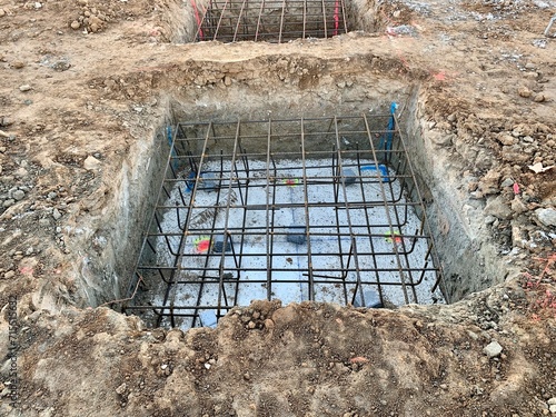 Concrete footings and reinforcing rod for new building under construction. Ground formwork and reinforcing steel for isolated foundations at construction sites.