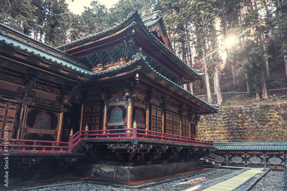 A temple surrounded by trees at sunrise in Nikko, Tochigi, Honshu, Japan A temple surrounded by trees at sunrise in Nikko, Tochigi, Honshu, Japan