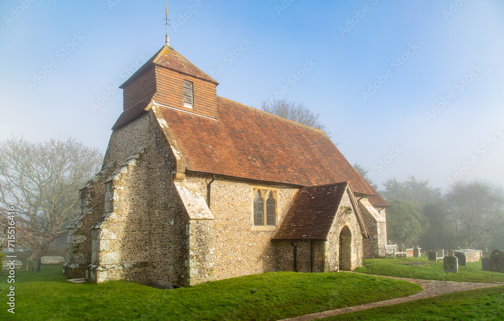 The 11th century Church of St. Mary The Virgin on a foggy winter morning, Friston, South Downs National Park, East Sussex, England The 11th century Church of St. Mary The Virgin on a foggy winter morning, Friston, South Downs National Park, East Sussex, England
