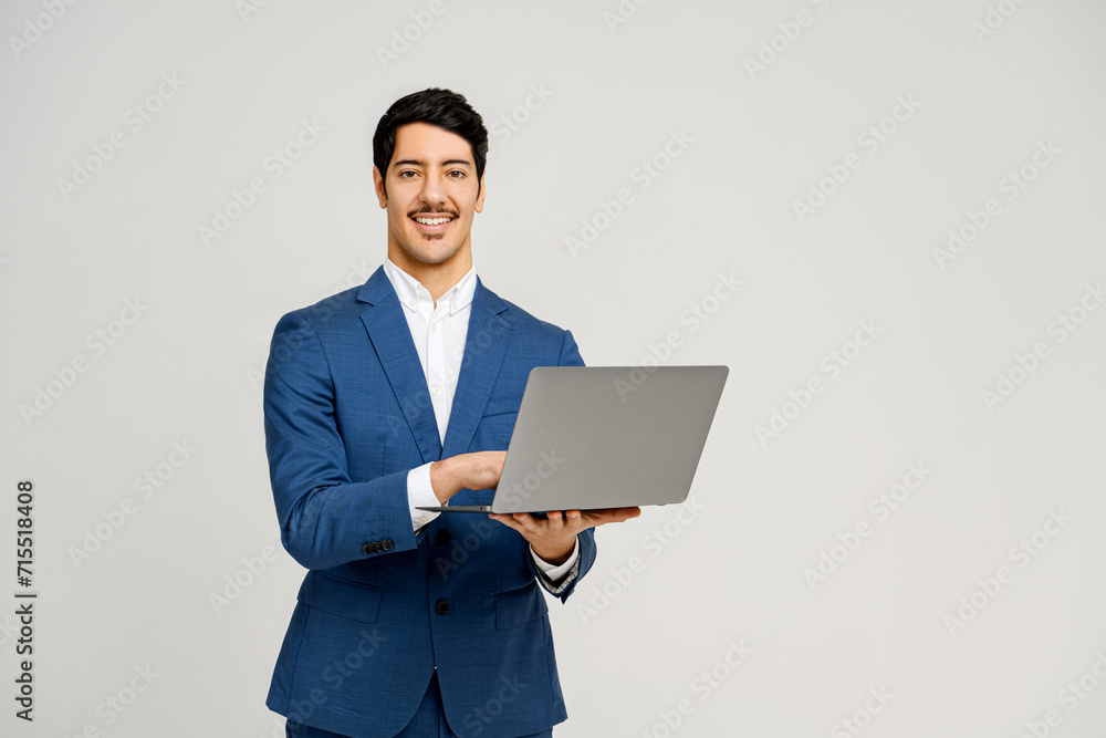 A charismatic businessman smiles while holding a laptop, symbolizing the ease and pleasure of modern technology in business, remote work, or the successful management of digital tasks A charismatic businessman smiles while holding a laptop, symbolizing the ease and pleasure of modern technology in business, remote work, or the successful management of digital tasks