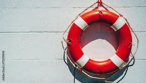 red lifebuoy with white strip hanging on white wall had space on left side for creative photo