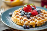 Close-up of a freshly baked waffle topped with a colorful array of berries, dusted with powdered sugar