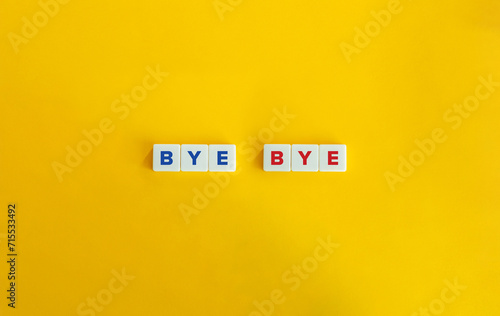 Bye Bye Text on Block Letter Tiles on Yellow Orange Background.