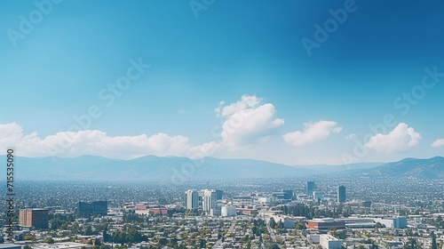 Aerial view of a city  with homes and buildings. clear blue sky with mountains in background.