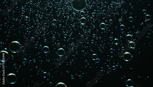 Bubbles floating in the water with dark background photo