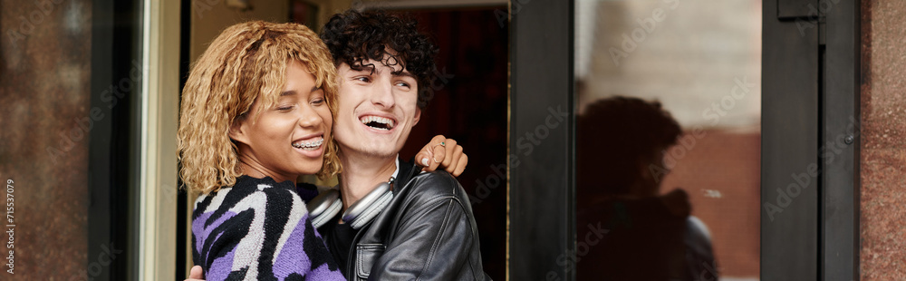 happy diverse couple in casual wear hugging by the entrance of vegan cafe, coffee date banner happy diverse couple in casual wear hugging by the entrance of vegan cafe, coffee date banner