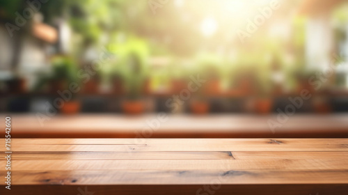 An empty wooden table top in focus with a beautifully blurred background of a lush green garden basking in sunlight. photo