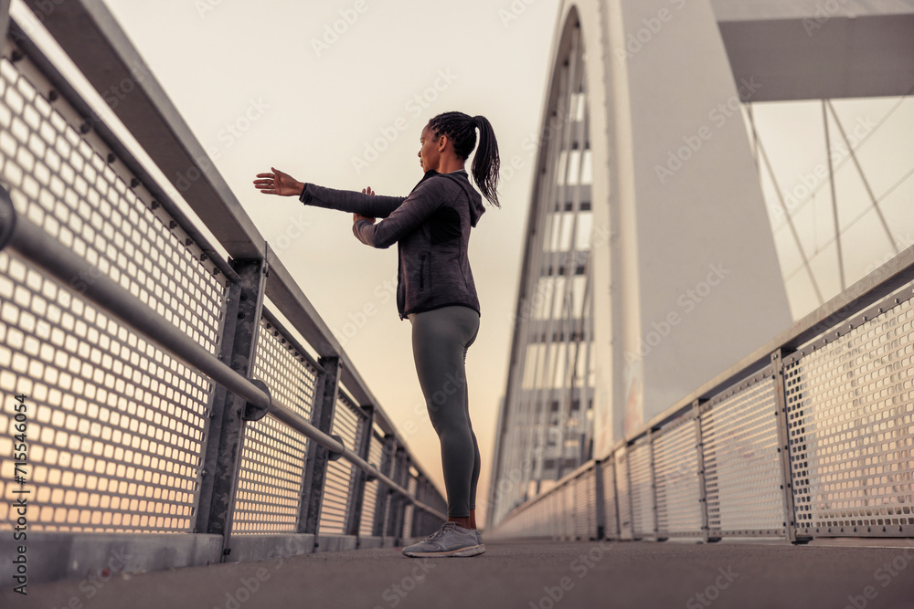Woman warming up for morning jogging session Woman warming up for morning jogging session